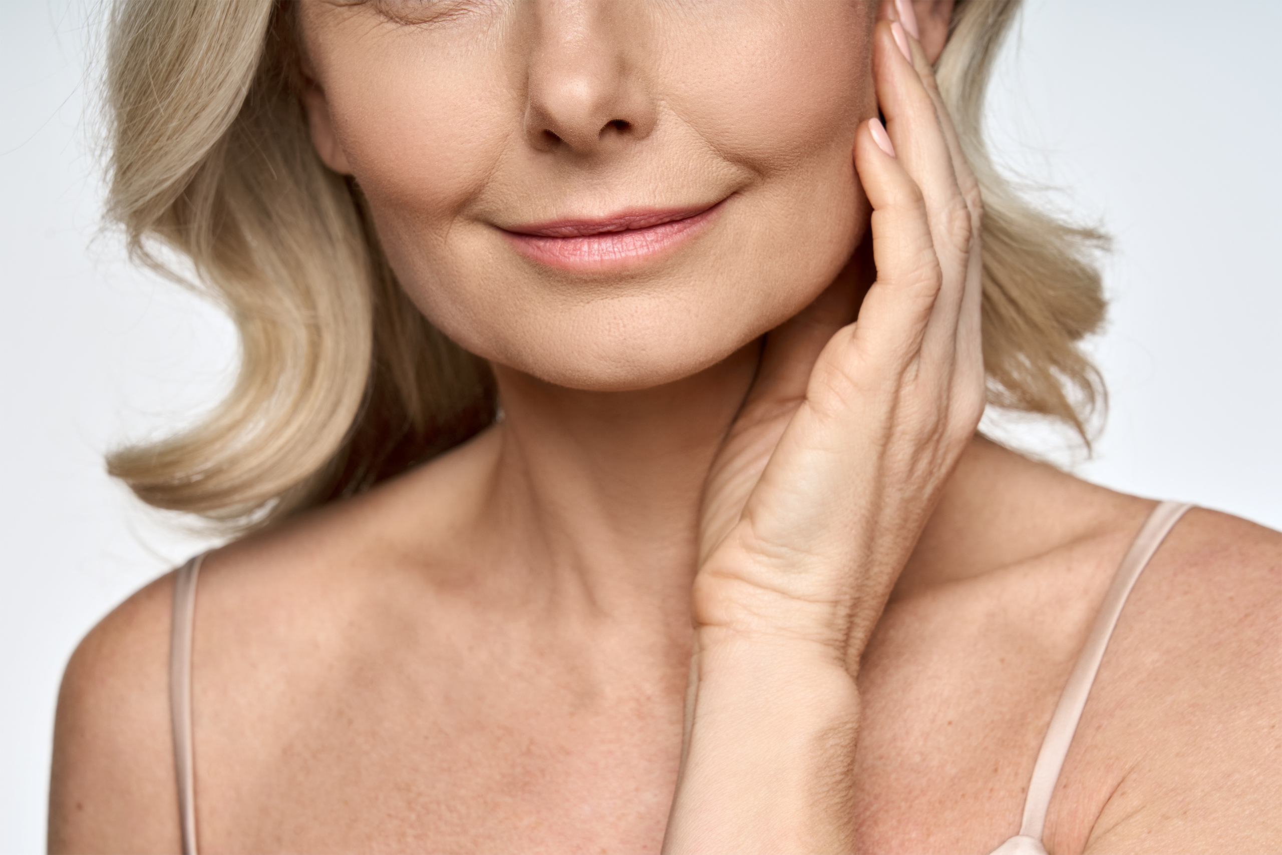 A beautiful adult woman's chin and neck is shown here to represent the concept of a neck lift vs. neck liposuction.