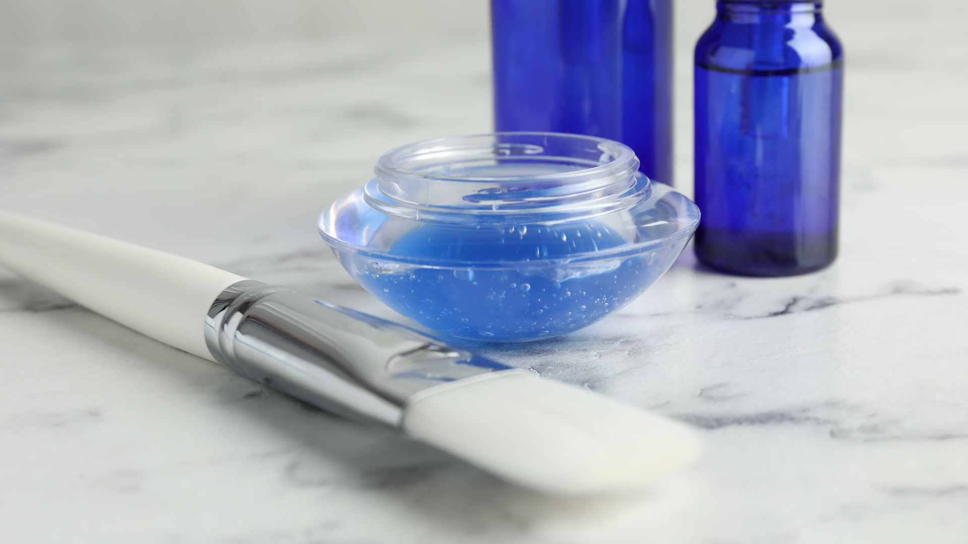 A close up of a brush with chemical peel and skin care products